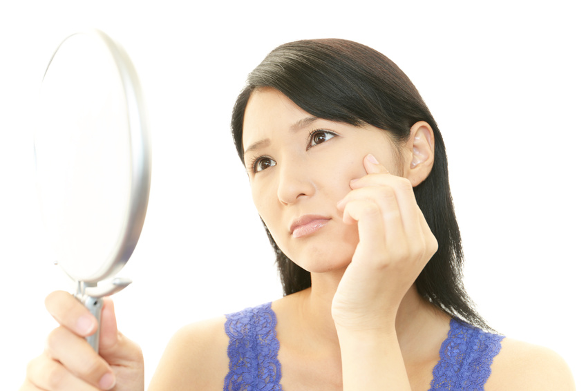 顔のシミを気にする女性