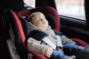 Portrait of toddler boy sleeping in car seat