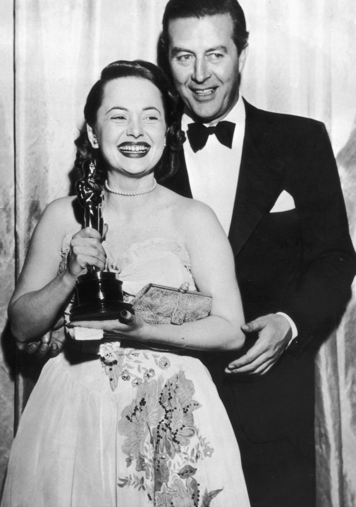 19th March 1947: Olivia de Havilland receives her Best Actress Oscar from actor Ray Milland (1907 - 1986) for her performance in 'To Each his Own', directed by Mitchell Leisen. (Photo by Keystone/Getty Images)