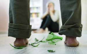 Woman victim of domestic violence and abuse. Mature woman scared of a man with broken bottle