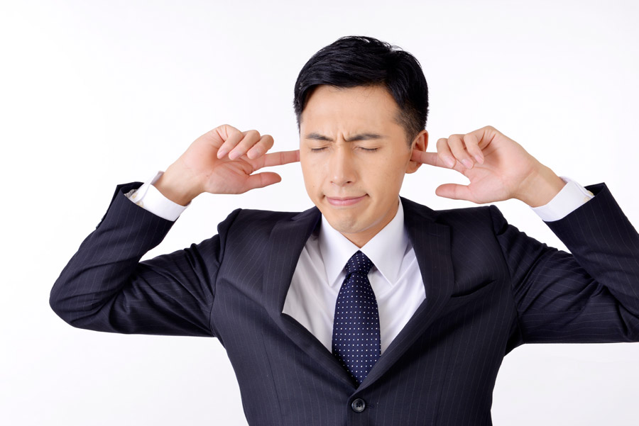 フリー写真 耳に指を突っ込んで耳を塞ぐビジネスマン