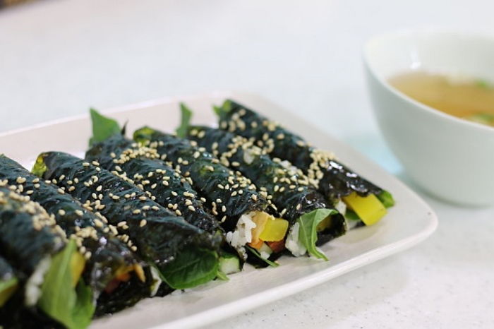 Playful mother and daughters laughing in bedroom