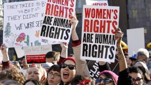 Women chant and raise their signs during a rally, part of International Women's Strike NYC, a coalition of dozens of grassroots groups and labor organizations, Wednesday, March 8, 2017, at Washington Square Park in New York. (AP Photo/Kathy Willens)