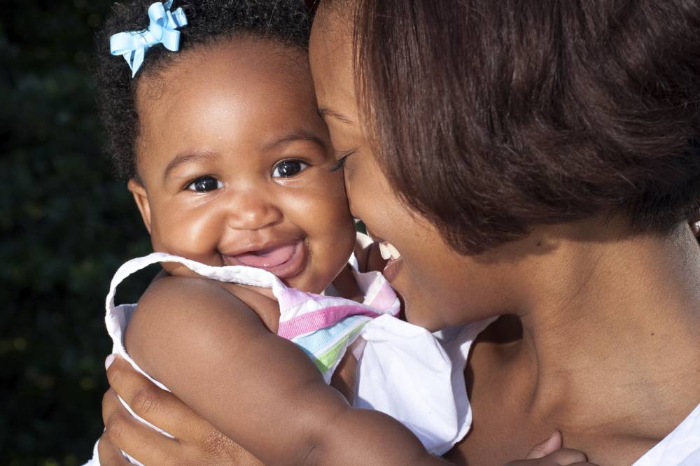 a happy new mother poses with her baby