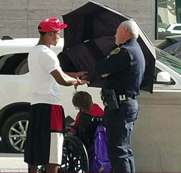 An image of Louis Jordan (L) shielding a woman from the scorching heat has gone viral over the Internet