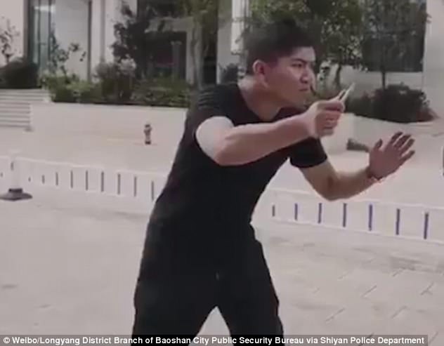 The camera then pans towards a man pretending to be the attacker, holding a knife