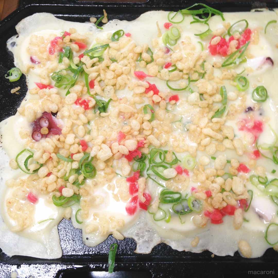 たこ焼きの具材を加えている様子