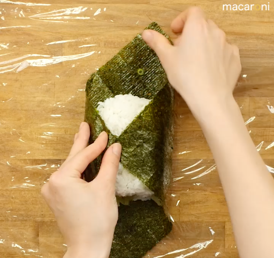 海苔でご飯と具材を包んでいる画像
