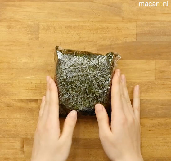 ラップで海苔とご飯を包んでいる画像