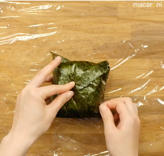 海苔で具材とご飯を包んでいる画像