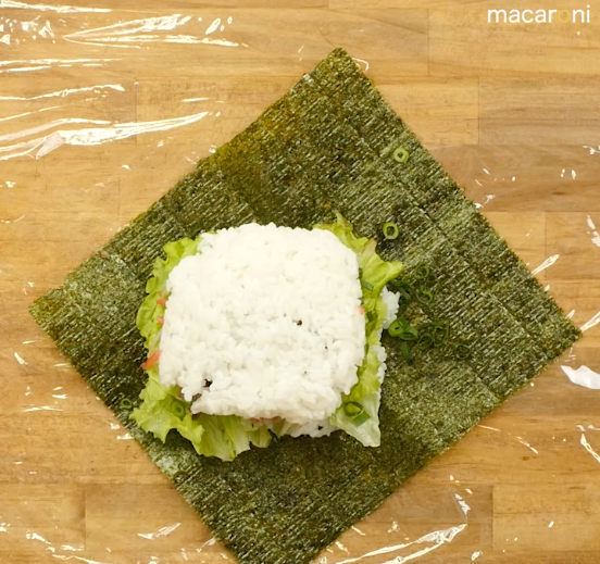海苔の上にご飯、具材をのせた上にさらにご飯をのせた画像