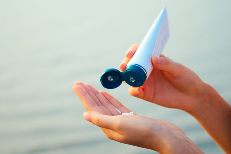 hand squeezes sunscreen on hand