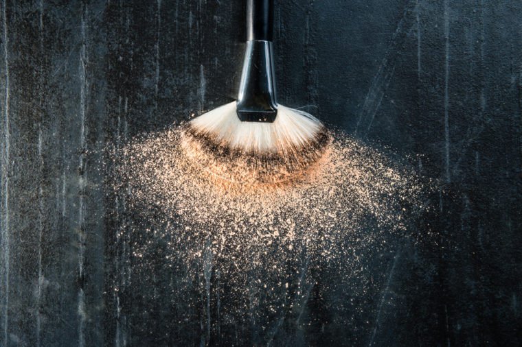 high angle view photo of fashion artist used cosmetic brush touching freeze makeup powder foundation on black stone texture floor background.