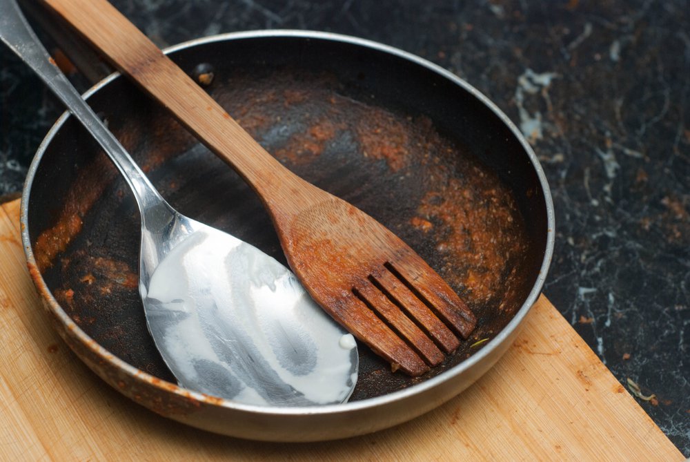 Dirty Pan with Tomato Sauce and Spoons. Dirty Dishes from the Cooking Process.