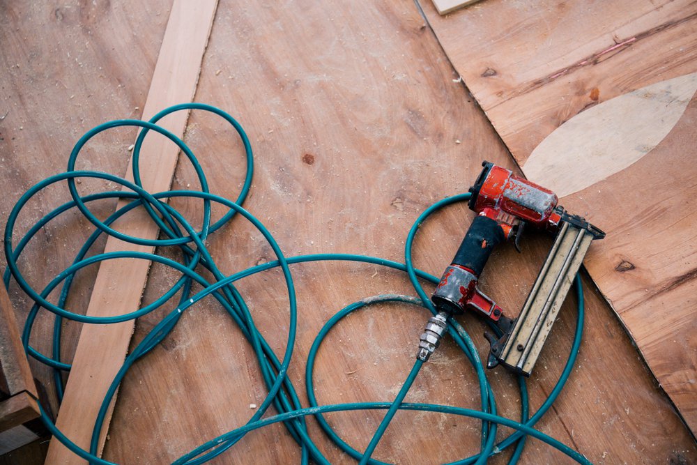 Nail gun tool with wood background in workshop.