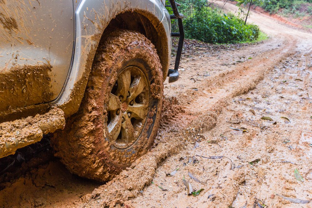 Wheel closeup in a countryside landscape with a muddy road