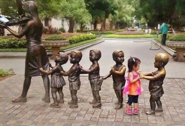 Funny People posing with statues 
