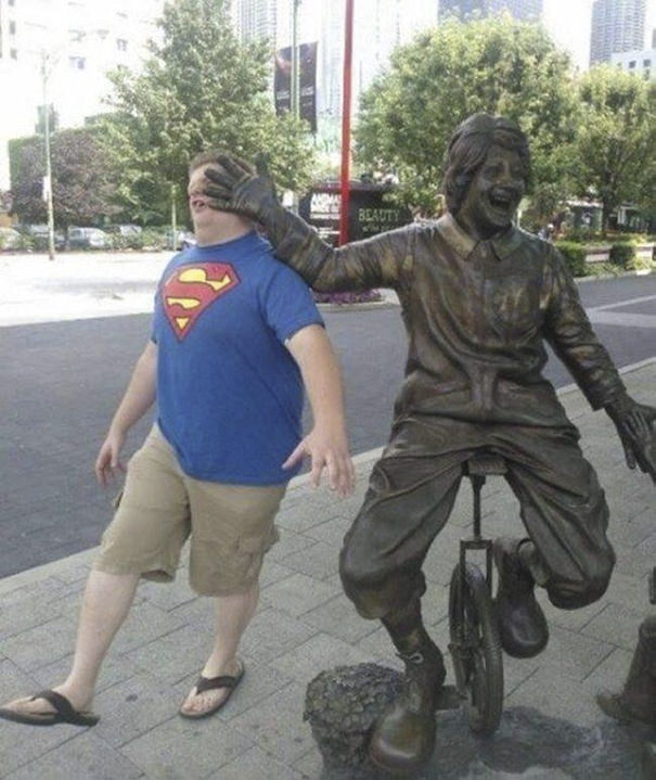 Funny People posing with statues 
