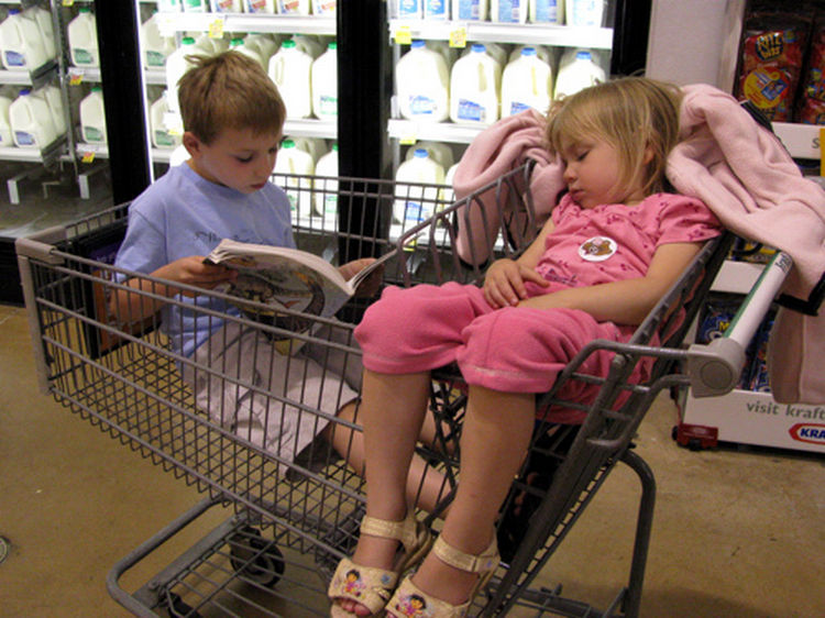 25 Kids Sleeping in the Strangest Places - Big brother reading a bedtime story.