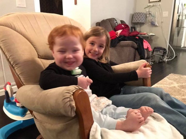 Image may contain: 2 people, people smiling, people sitting and baby