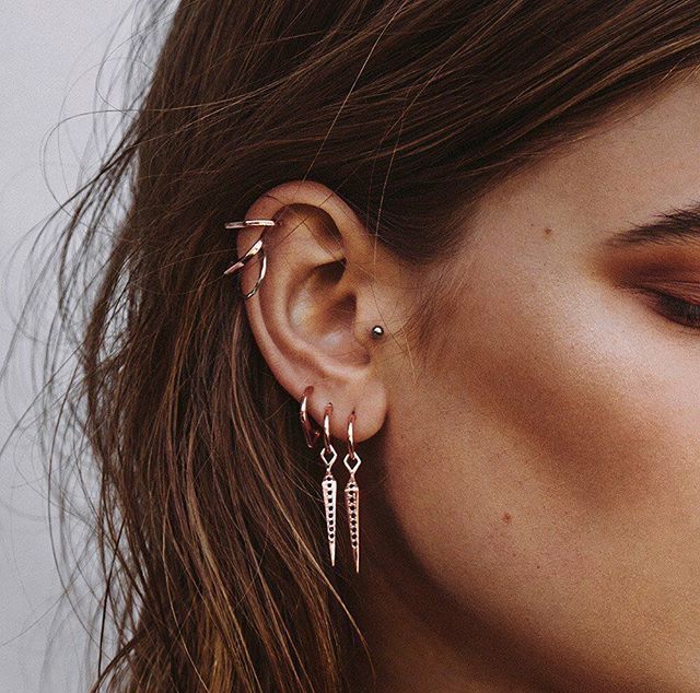 oreja de mujer con pearcings y aretes 