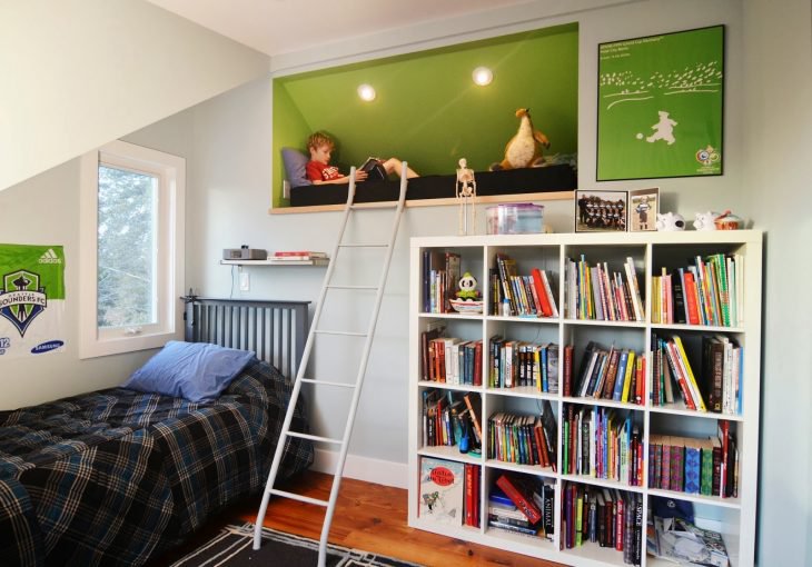 Niño leyendo un libro en su recámara en un rinconcito alto