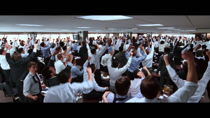 Escena del lobo de wall street donde los empleados están motivados levantando su mano
