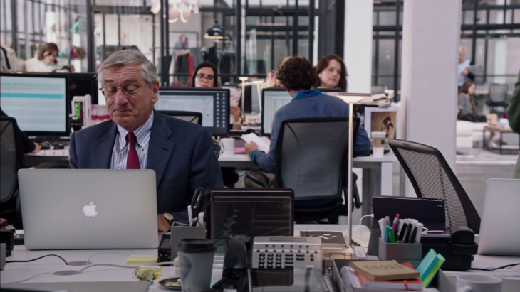 Jefe sentado con los empleados frente a una laptop