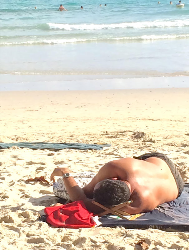 This Man At The Beach Has A Tiny Deck Chair To Rest His Head