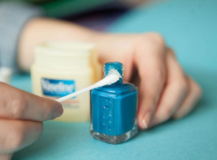 esmalte de uñas azul y cotonete con vaselina