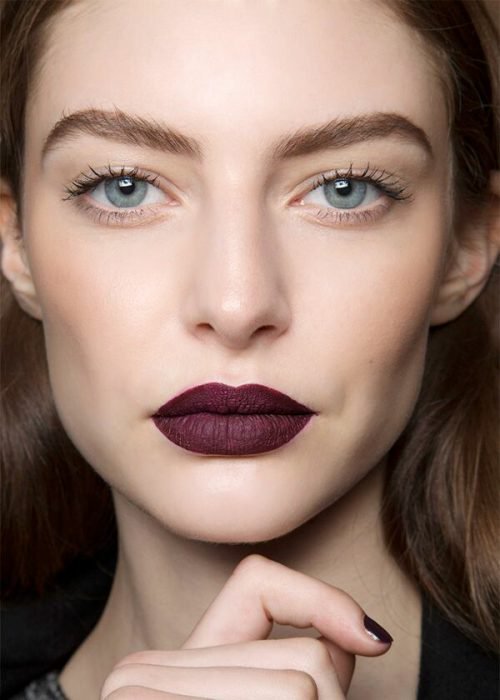 Mujer usando un labial color rojo en tono mate