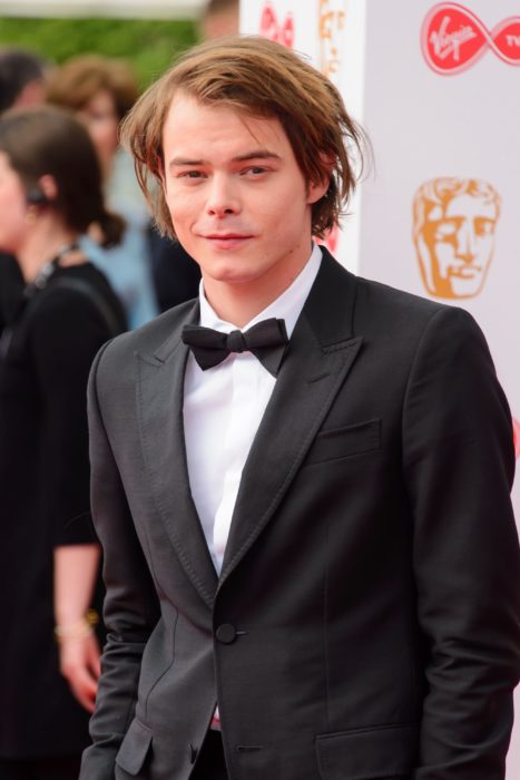 Charlie Heaton usando un traje mientras desfila por la alfombra roja de los premios BAFTA
