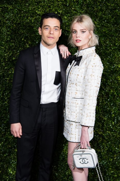 Rami Malek y Lucy Boynton abrazados posando para una foto durante la alfombra roja de la pasarela de Chanel