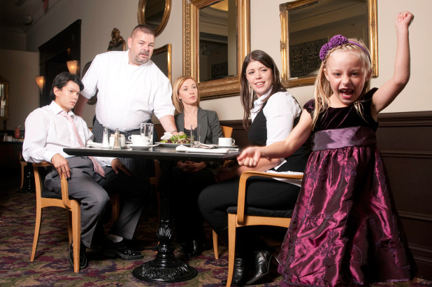 A little girl is acting up in a restaurant while diners look on