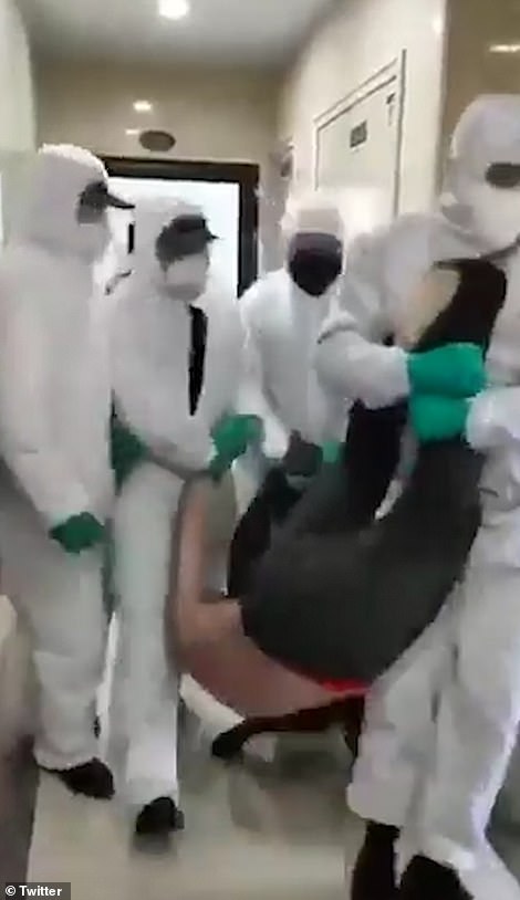 Several officials pick up one man, who had been resisting their efforts, and carry him down the stairs in the disturbing video