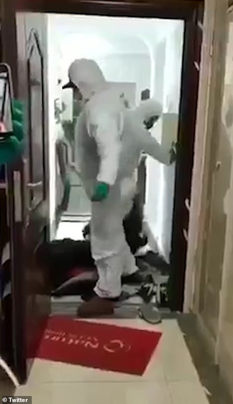 The footage, thought to have been filmed in Wuhan, China, shows officials in protective suits forcefully removing people suspected of having coronavirus from their home
