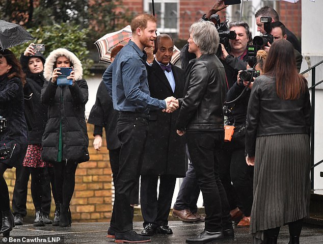 Harry shakes hands with Jon Bon Jovi Abbey Road studios this morning before recording a duet