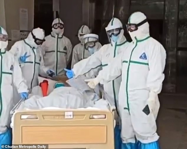 A group of medical workers are seen escorting Ms Zhang out of the hospital yesterday