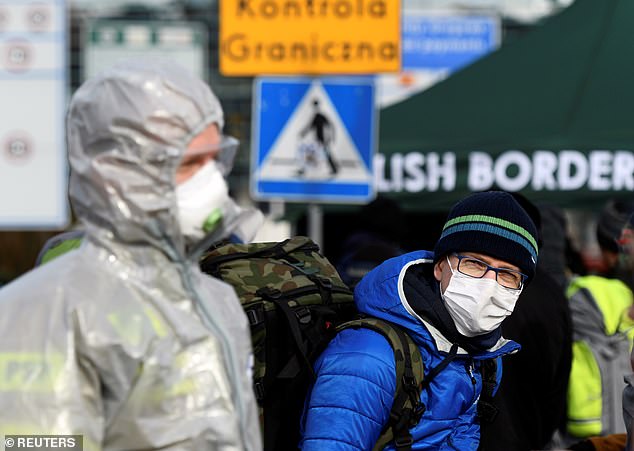 A man wearing a face mask stands on the Poland-German border crossing point on Sunday