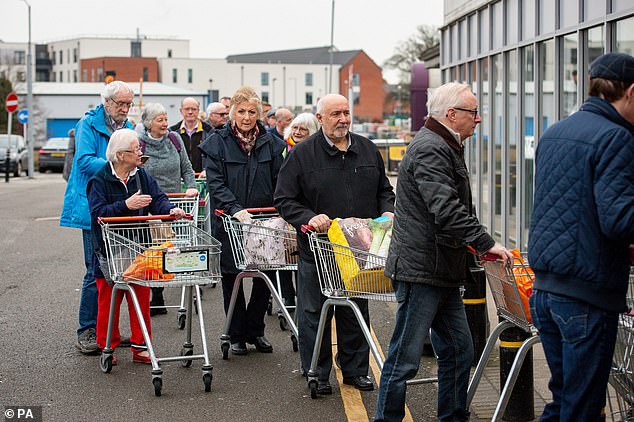 Older customers queue outside a Sainsbury