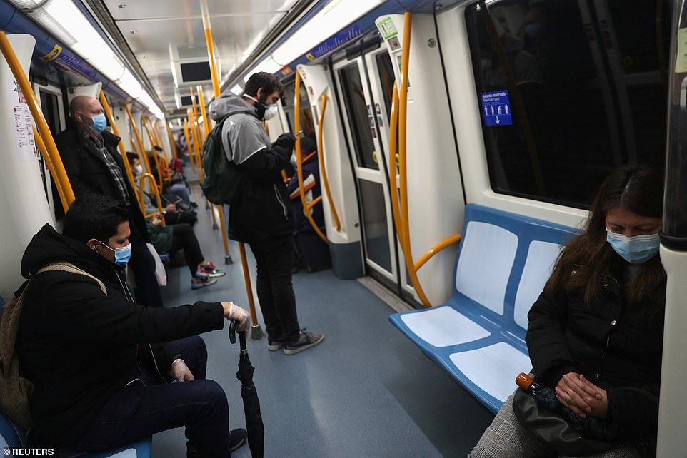 Passengers keep their distance riding the metro in Madrid as non-essential workers are allowed back to work today