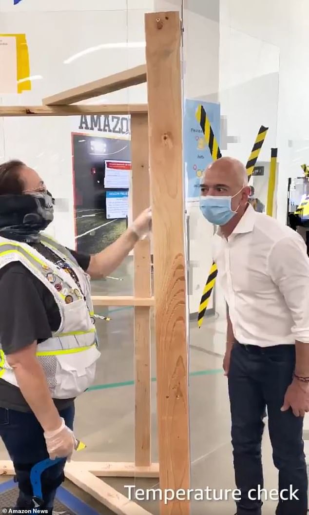 The economic damage for most has been widespread and severe amid COVID-19 But under lockdowns Amazon has seen a surge in demand for online orders. Bezos is pictured wearing a mask and having a temperature check at a facility in Dallas last week where an employee later tested positive
