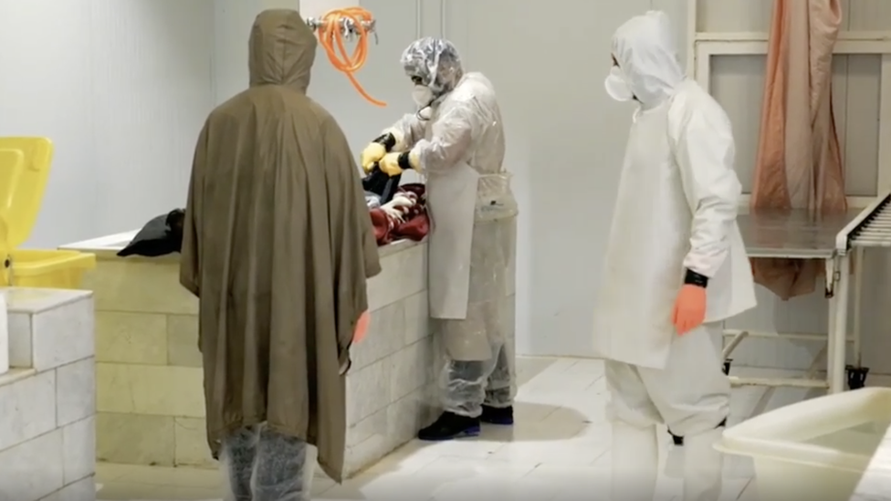 Workers washing dead bodies