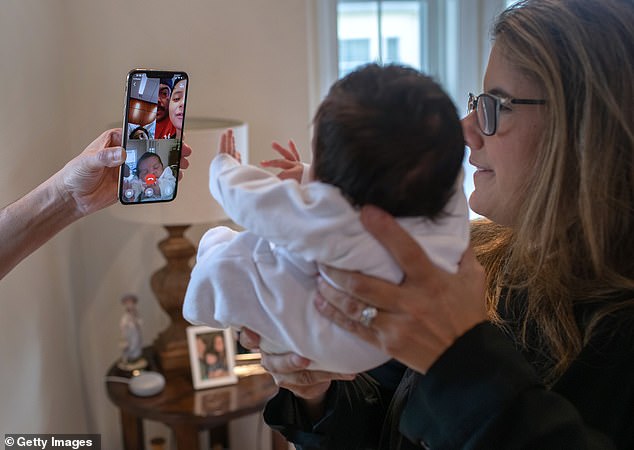 Luciana is pictured holding up baby Neysel so he can be introduced to his family