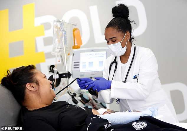 To be considered recovered, patients must have no fever for 72 hours without drugs and two negative tests results taken at least 24 hours apart. Pictured: Phlebotomist Jenee Wilson talks with Melissa Cruz, an ER technician who has recovered from coronavirus, as she finishes donating plasma in Seattle, Washington, April 17