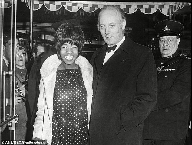 The singer arriving with Lord Montagu of Beaulieu at the Casino Cinerama Theatre in Old Compton Street, London, for the world premiere of 