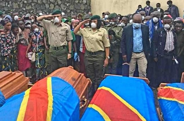 Military personnel salute over the coffins of the Virunga national park rangers last month