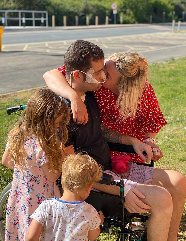 Omar Taylor, in wheelchair, is visited in hospital for the first time in six weeks by his wife Kaitlyn and children Vivienne, four, and Harrison, who is almost two