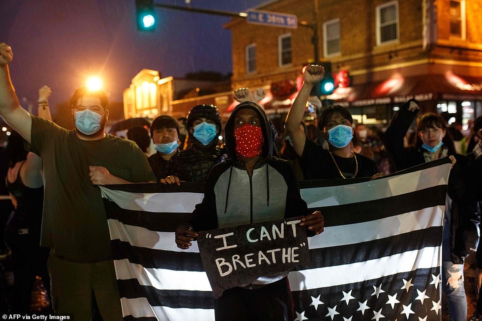 Protesters raised their fists and sported face masks to protect them from the spread of COVID-19 as they gathered for the rally near the spot where Floyd died