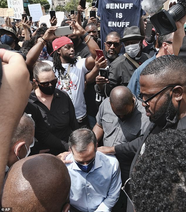 Joined by community faith leaders Los Angeles Mayor Eric Garcetti takes a knee in prayer during a Black Lives Matter protest in downtown Los Angeles on Tuesday